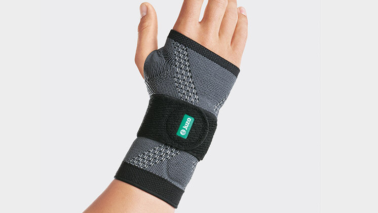A shop assistant at the bakery wears a wrist brace at work