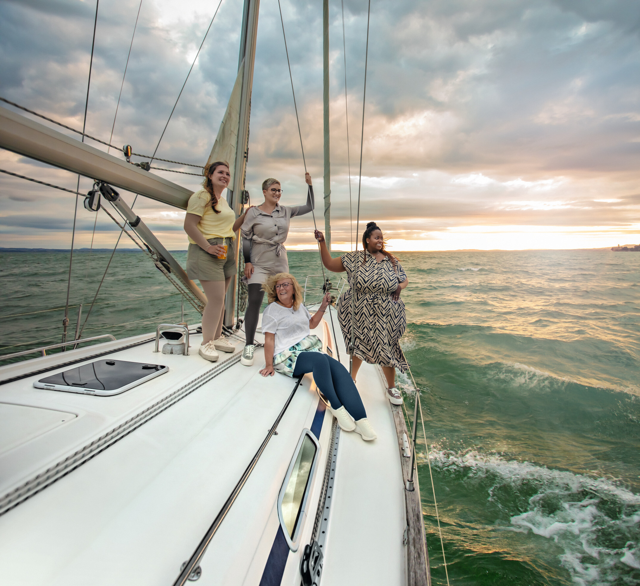 Gruppo di persone su una barca a vela al tramonto, molte delle quali indossano calze compressive. Gruppo di persone su una barca a vela al tramonto, molte delle quali indossano calze compressive.