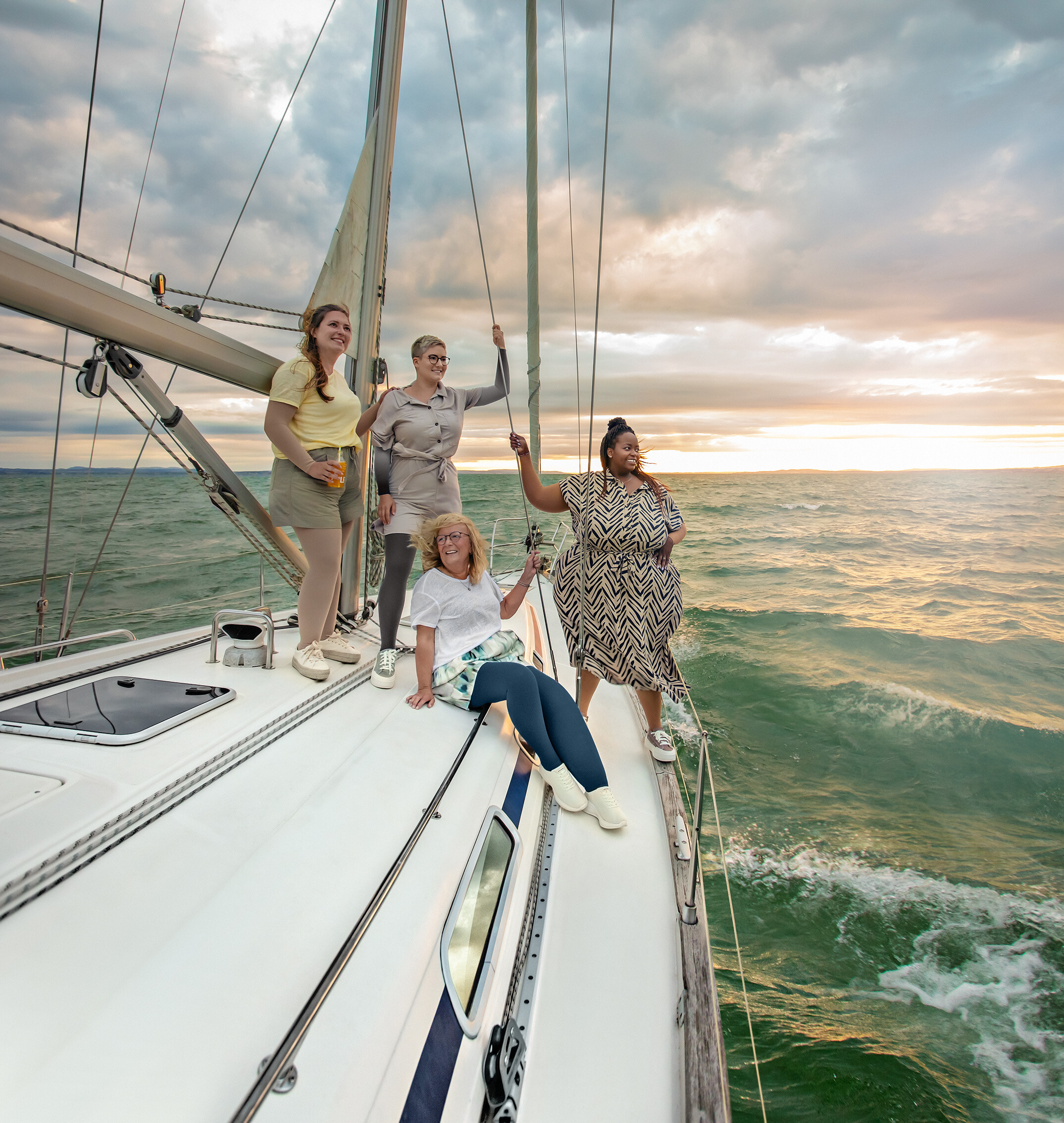 Groupe de personnes sur un voilier au coucher du soleil, plusieurs d'entre elles portent des bas de contention. Groupe de personnes sur un voilier au coucher du soleil, plusieurs d'entre elles portent des bas de contention.