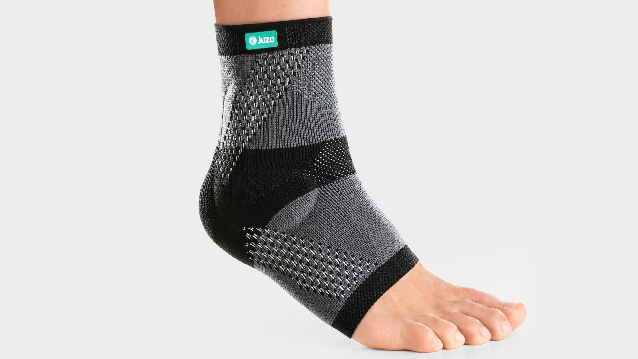Someone is running along a dirt track, wearing an ankle support